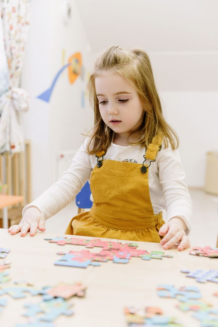 why-choose-us A child focused on solving a colorful puzzle at home.
