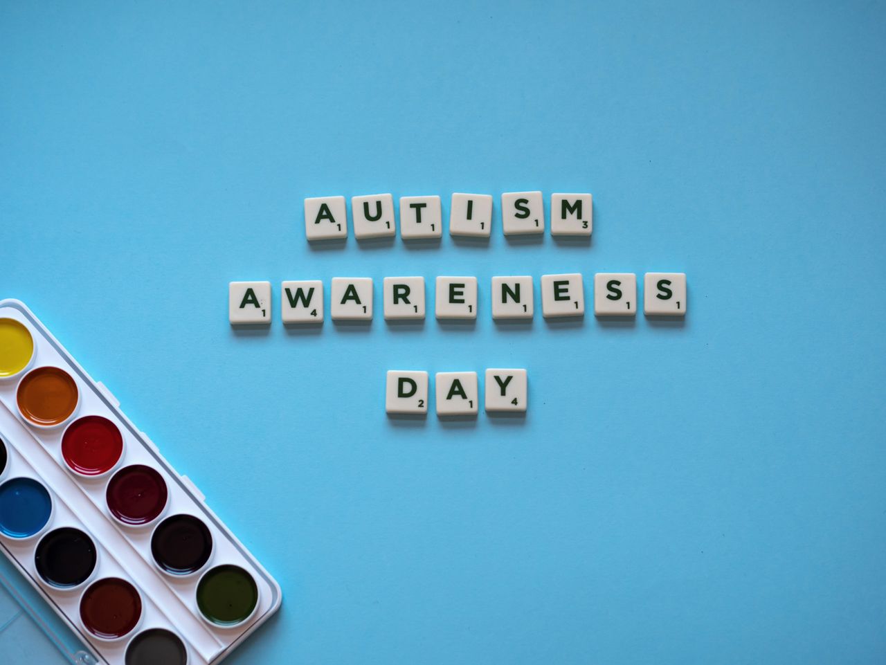 services-02 Flat lay of autism awareness day message on blue background with watercolor paints.
