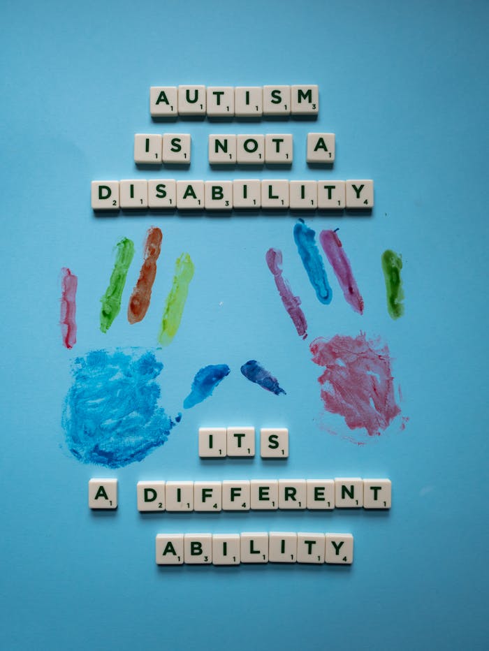 services-01 Creative composition with Scrabble tiles and paint promoting autism awareness and acceptance.