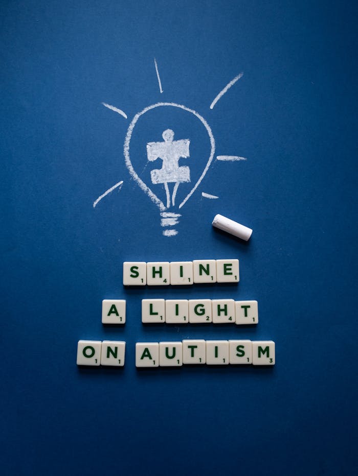 about-01 Chalk-drawn light bulb with autism puzzle piece on blue background, promoting awareness.