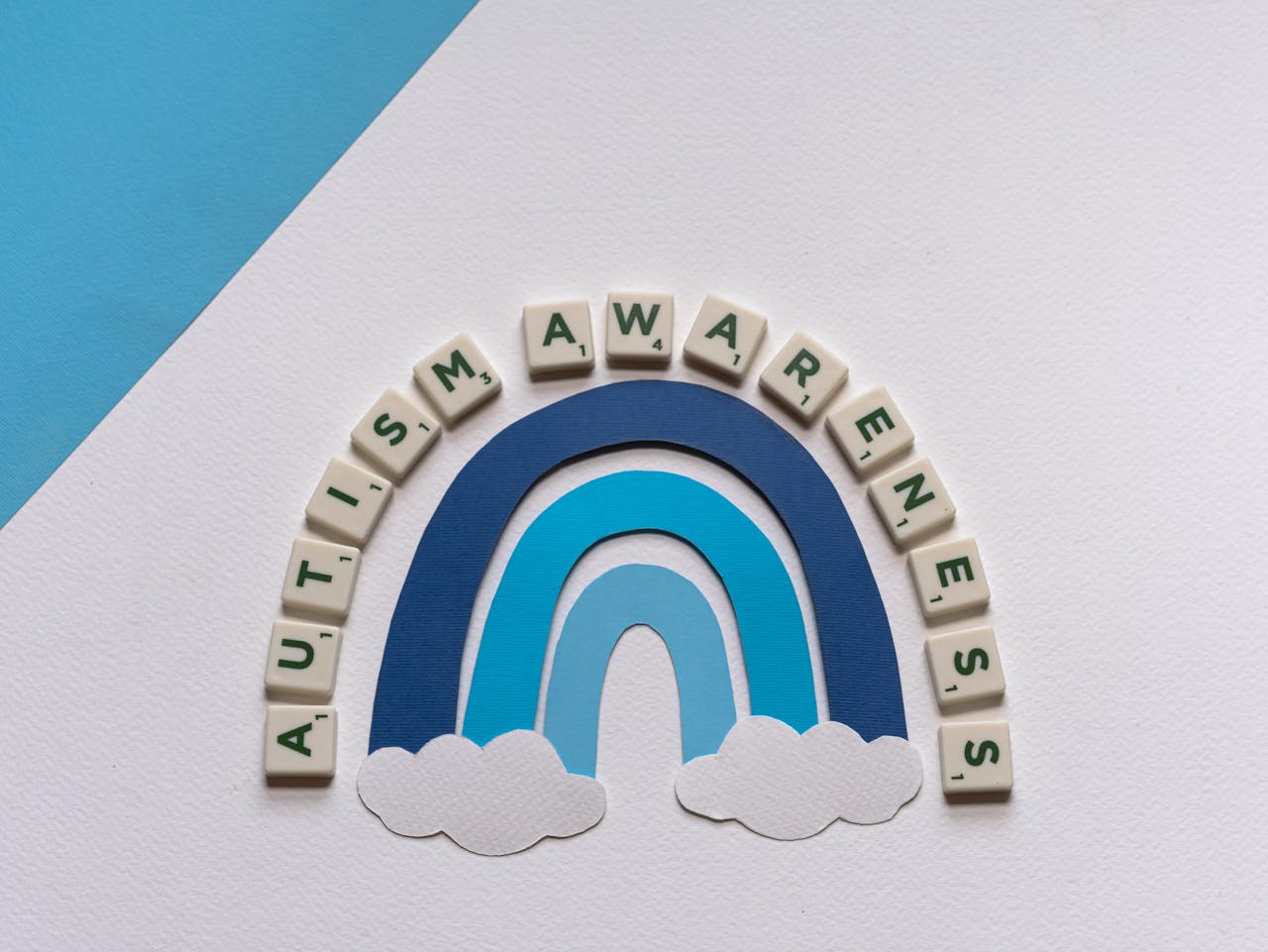 services-img Styled autism awareness design featuring rainbow and letter tiles.